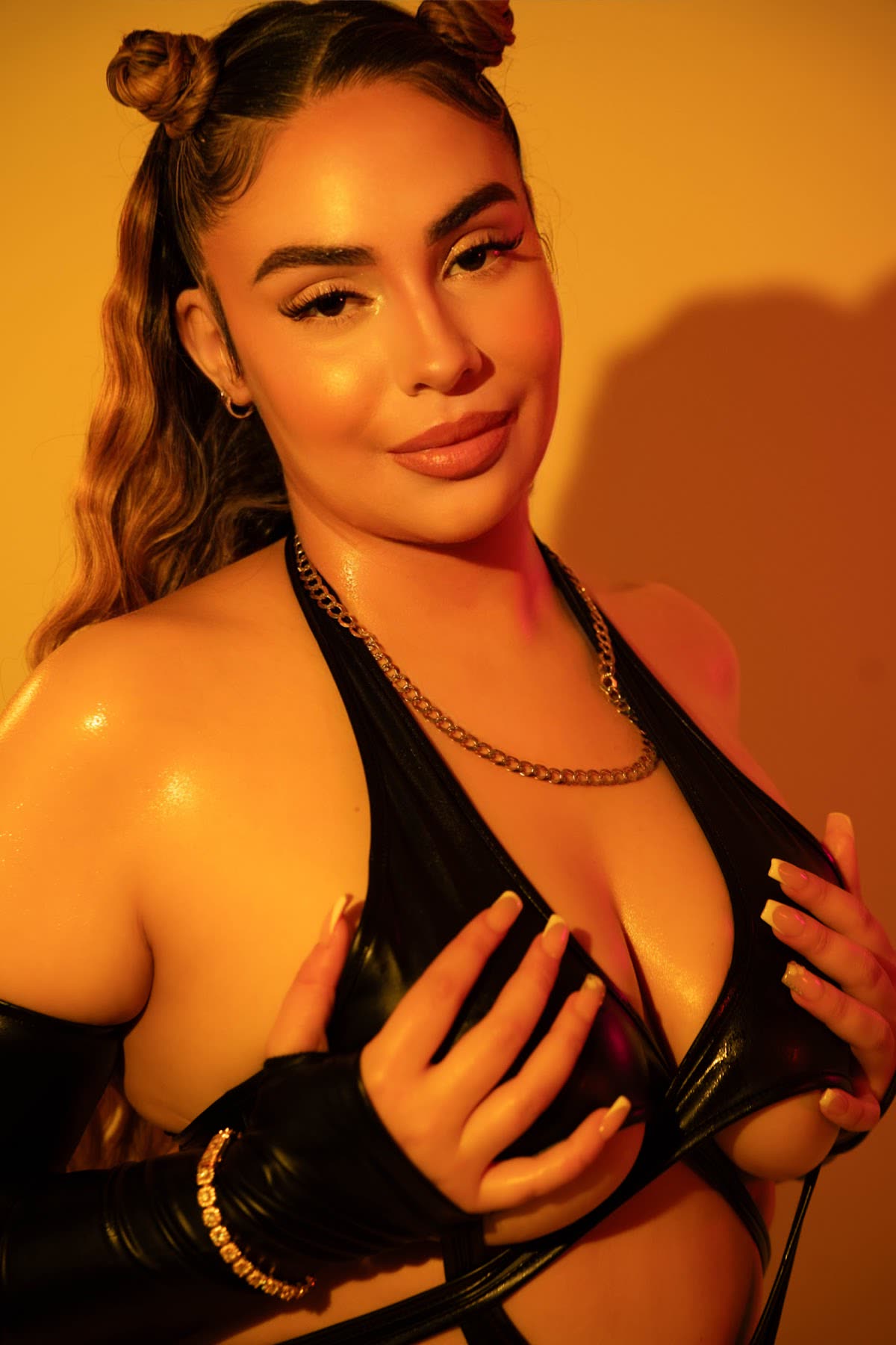 Portrait of a woman in a black outfit under warm amber studio lighting