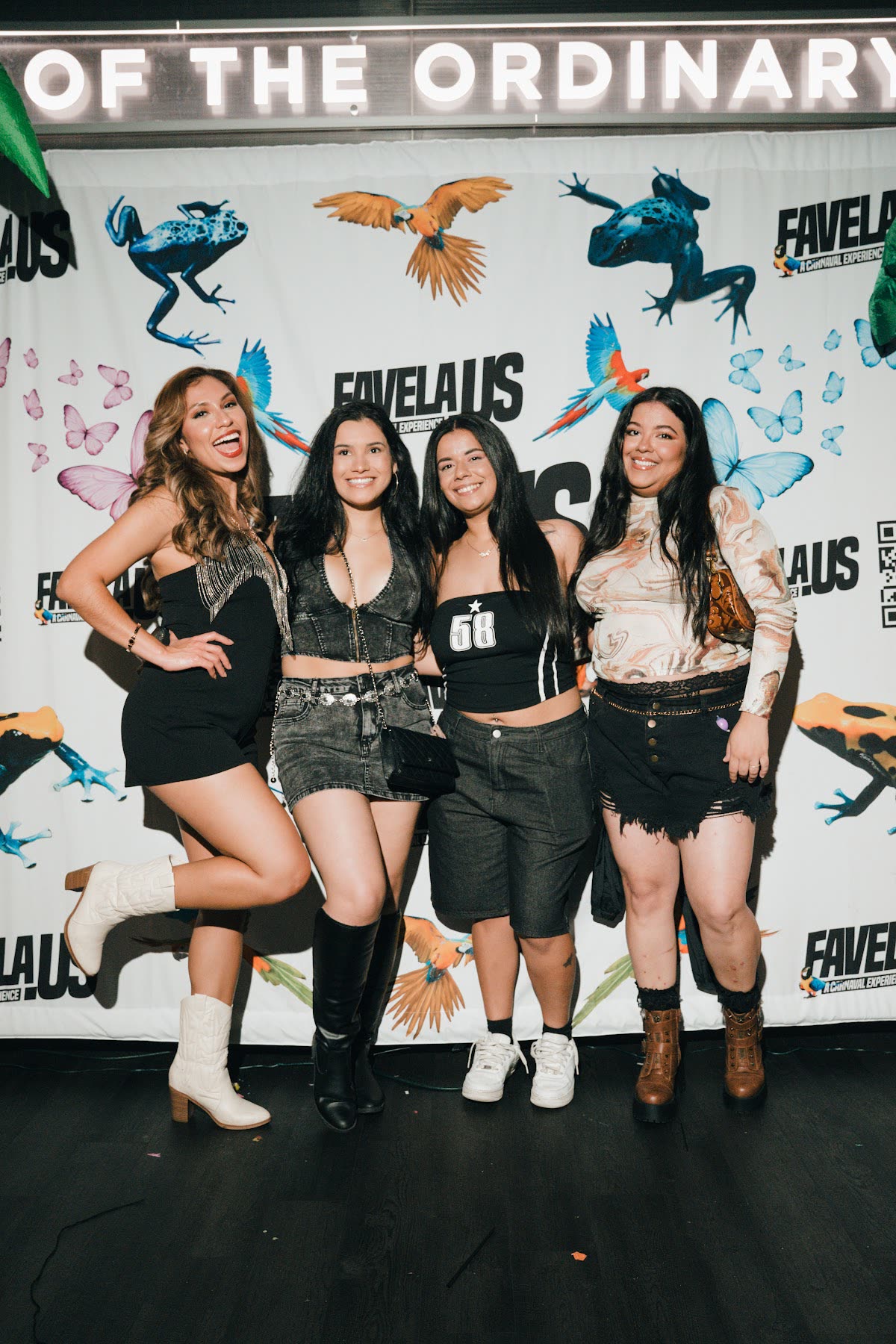 Guests posing together in front of the Favela event backdrop
